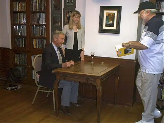 Dick Francis is happy to sign a book for another fan.